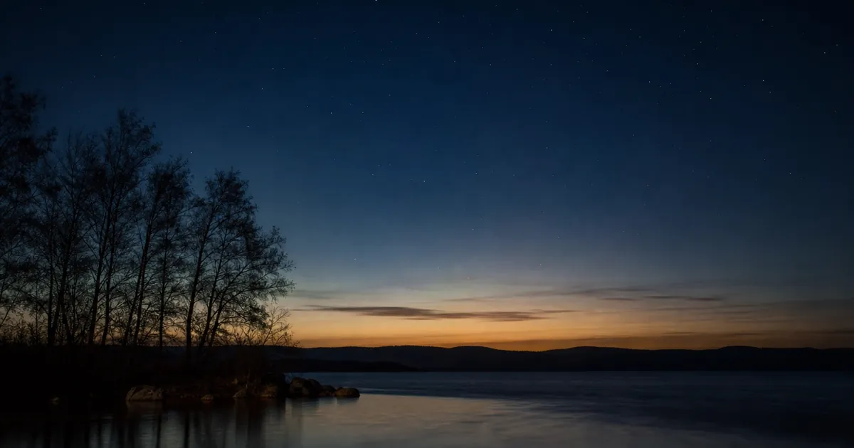 Vårnatt över en stilla sjö med svaga stjärnor lågt i söder
