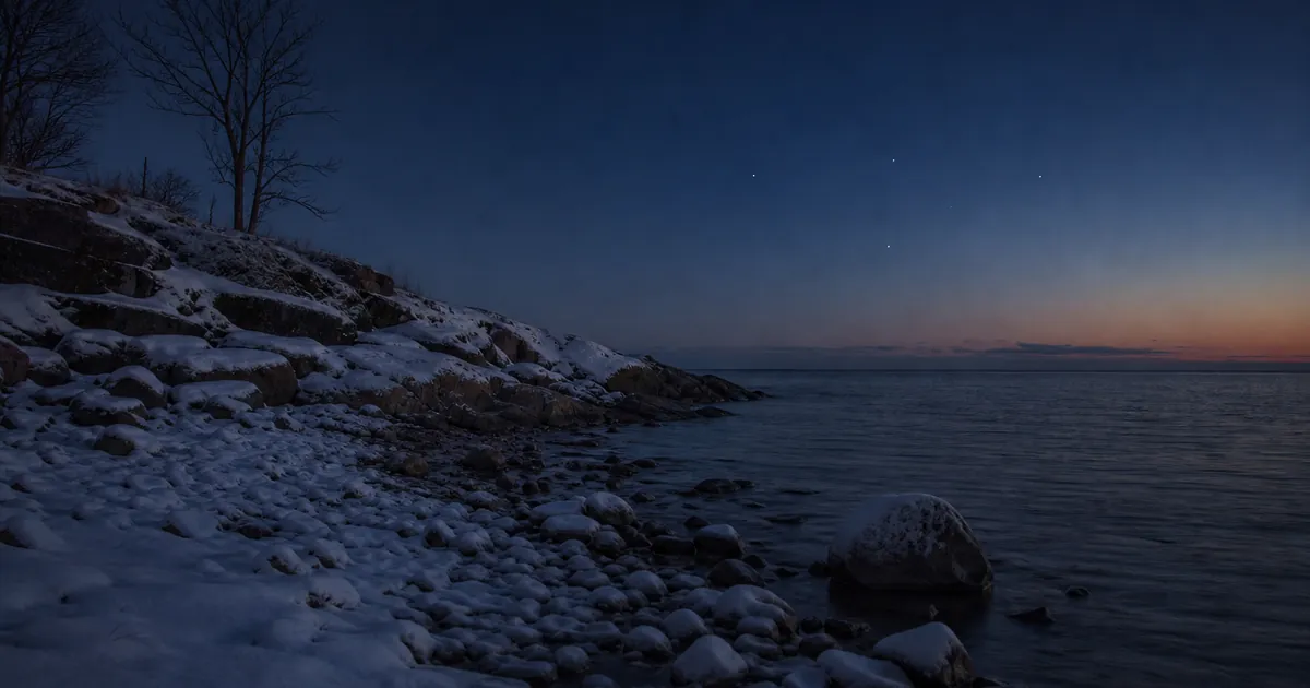 Vinternatt vid havet i södra Sverige med några stjärnor precis över horisonten